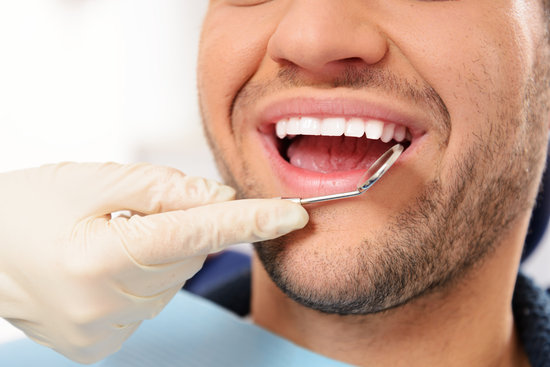 Man doing teeth checkup at dentist's surgery